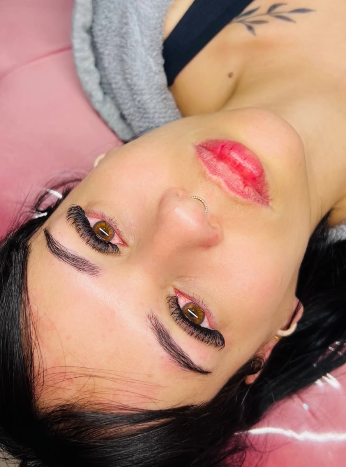 Cílios e sobrancelhas de cliente sobre a maca rosa do Studio